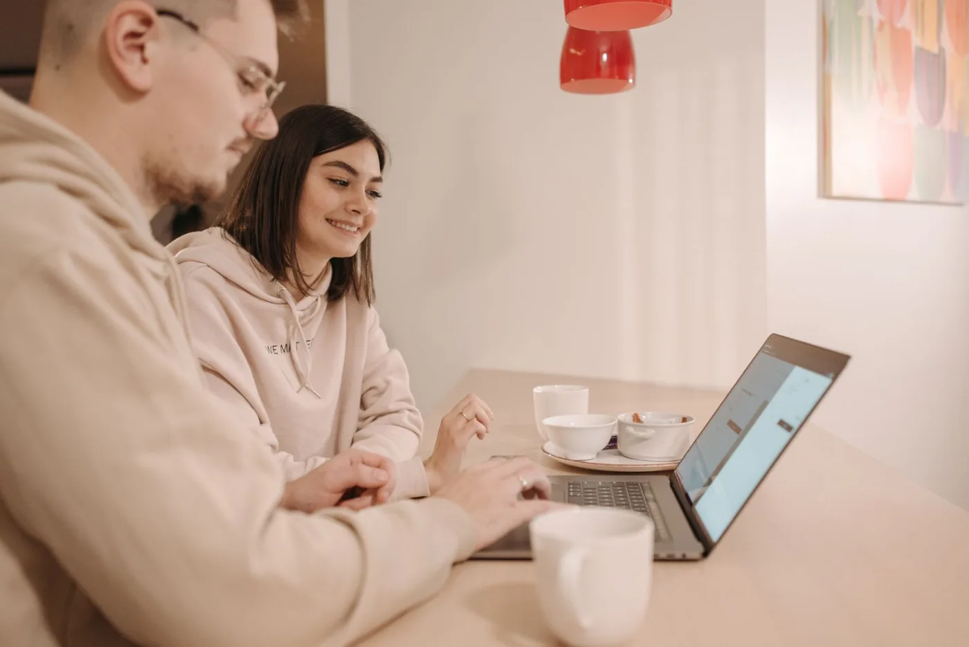 Deux personnes regardent ensemble un écran d'ordinateur portable dans un café